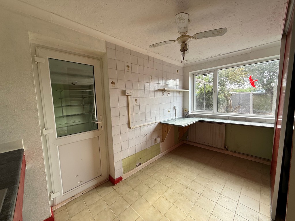 Lot: 163 - THREE-BEDROOM DETACHED HOUSE FOR IMPROVEMENT - Tiled kitchen with window and doors to utility room